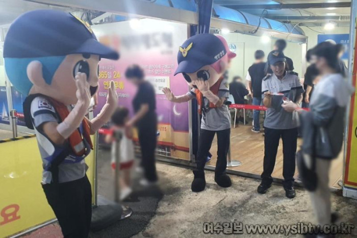 [크기변환]해양경찰관들이 해양공원에서 관광객들에게 구명조끼 중요성을 홍보하고 있다.jpg